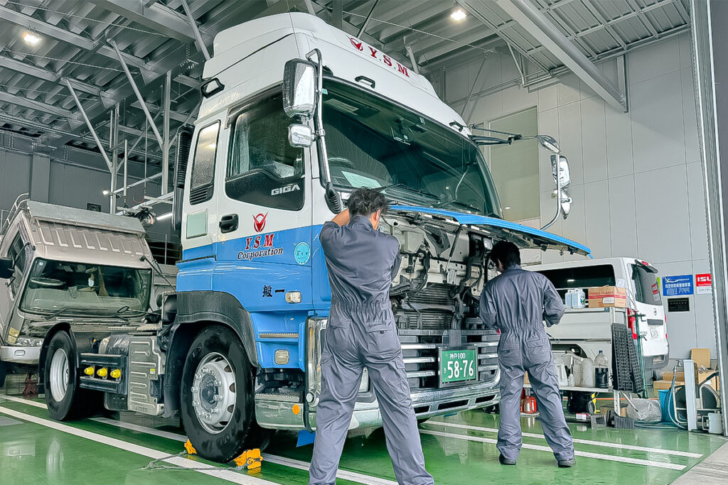 トラックのバンパー内を点検するスタッフ